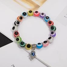 Detailed close-up of colorful Evil Eye beaded bracelet with silver Hamsa Hand charm