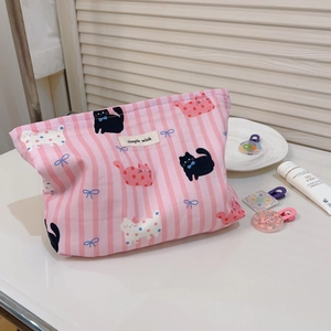 Détail d'une trousse à maquillage en toile rayée rose avec motifs chats mignons
