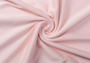 Close-up of pink knitted fabric detail showing high elasticity and soft texture
