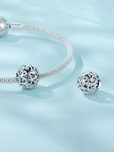 Macro shot of S925 sterling silver hollow filigree bead with zircon on mesh bracelet