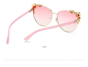 Detail view of pink gradient cat-eye sunglasses with gold metal floral ornaments