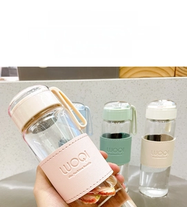 Detail view of the heat-resistant glass water bottle with protective sleeve and carry handle