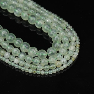 Cordons de perles en préhnite vert clair naturel de tailles variées sur fond noir