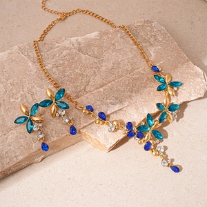 Vintage gold jewelry set featuring flower pendants with blue crystals on stone
