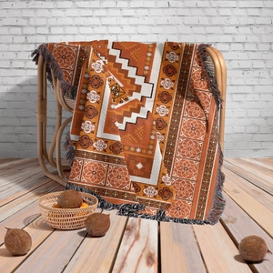Close-up of bohemian knit blanket with orange geometric patterns and colorful tassels