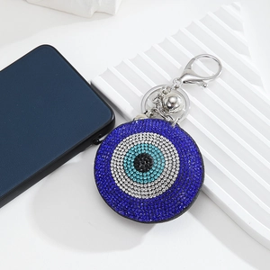 Detail of Turkish blue evil eye keychain with sparkling rhinestones and silver bells