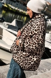 Outdoor shot of a women leopard print quilted jacket styled with a white knit beanie