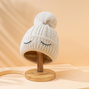 Berretto in maglia beige foderato in pile con pompon e ciglia ricamate carine