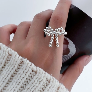 Close-up of S925 sterling silver beaded stretch ring with a polished bow design for women