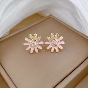 Close-up of golden sunflower stud earrings with pink enamel and sparkling zirconia