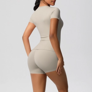 Detail of high-waist beige yoga shorts and slim-fit t-shirt shown from a side-back view