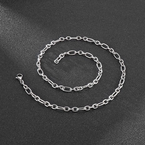 Detailed view of silver stainless steel Cuban link chain with lobster clasp on dark surface