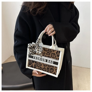 Close-up of leopard print handbag with white leather handles and fashion scarf detail
