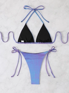 Flat lay of purple metallic laser bikini set with adjustable side ties on marble surface