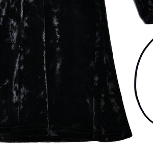 Detailed close-up of premium black velvet dress hem with elegant lace-up strap details