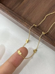 Detail of gold heart pendant with radial brushed texture on a delicate chain necklace