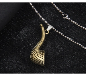 Vue macro d'un pendentif club de golf en bronze vintage avec texture sur chaîne argent