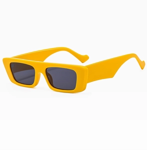 Close-up of bright yellow rectangular sunglasses with thick temples and dark lenses