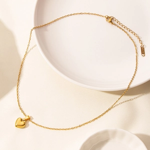 Close-up of golden heart pendant necklace with lobster clasp and adjustable chain link