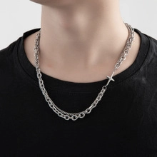 Detail view of a double-layer silver titanium steel snake chain with cross pendant on neck
