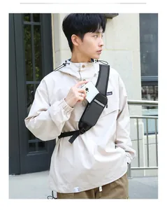 Detail of a tactical black chest bag with reflective strips holding a smartphone