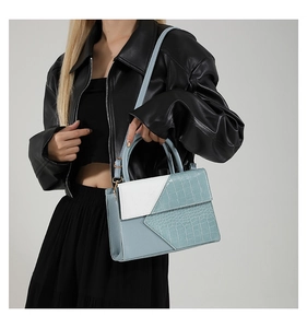 Vue détaillée du sac à main trapèze bleu et blanc avec texture crocodile sur mannequin