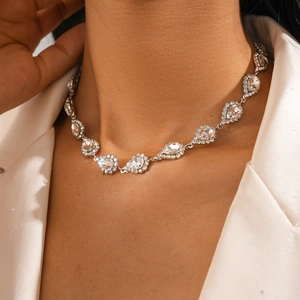 Détail d'un collier argenté élégant avec cristaux en forme de poire sur un mannequin
