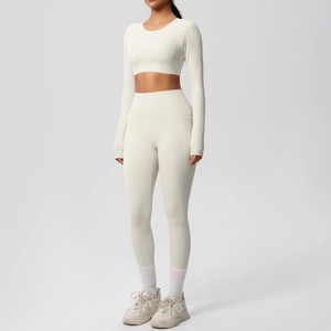 Detail of high-waist yoga leggings with side pockets and long sleeve crop top in cream white