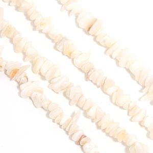Macro view of irregular natural shell stone beads for DIY jewelry making on white base