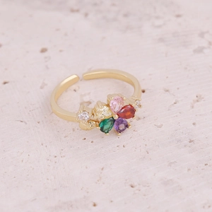 Macro shot of gold adjustable ring featuring a colorful petal pattern of teardrop gemstones