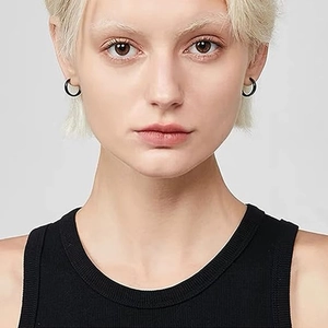 Close-up of a model wearing small black minimalist stainless steel hoop earrings