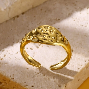 Macro detail of gold-plated stainless steel ring with hammered lava texture on stone
