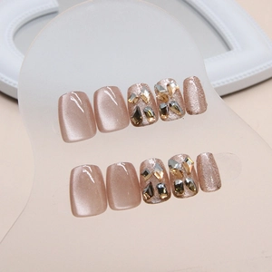 Short coffin press-on nails in champagne gold cat-eye glitter with rhinestone accents
