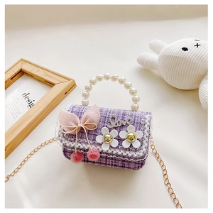 Detailed shot of purple tweed kids bag with pearl handle and floral bow charms