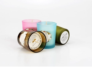 Detail view of frosted glass scented candle jars and safety labels on the bottom