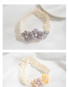 Macro detail of handmade lace baby headband with fabric flowers and pearl accents