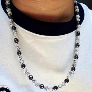 Close-up of men's beaded necklace featuring black hematite and white marbled tiger eye stones