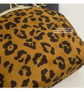 Detailed macro of leopard print shell bag with golden metal frame and chain link