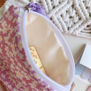 Détail du porte-monnaie en coton violet clair avec imprimé marguerites et fermeture éclair