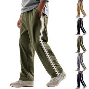 Detail view of men's loose-fit corduroy trousers with contrast side stripes in five colors