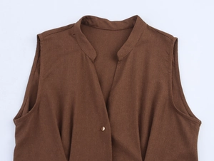 Detail view of deep brown linen fabric texture with V-neckline and bronze button design