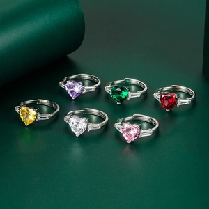 Close-up of six colorful heart-shaped zirconia rings with adjustable silver bands
