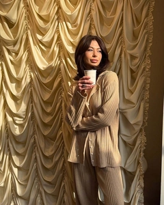 Detailed view of the pleated texture on this beige polo collar knit set worn by a model
