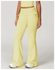 Detail of high-waist yoga flared pants with drawstring side ruching in soft yellow