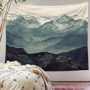 Detailed view of large mountain landscape tapestry in deep blue and beige in a bedroom