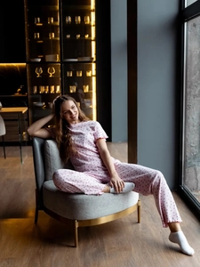 Ensemble pyjama rose à imprimé cœurs avec détails à volants dans un décor de salon