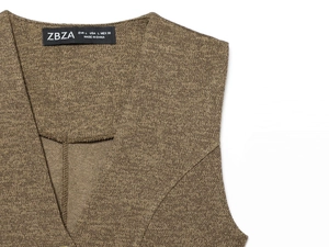 Detail of V-neck neckline with ZBZA brand label on tan textured knit midi dress