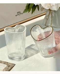 Detailed view of heart-shaped glass cup with vertical ribs and elegant gold-rimmed design