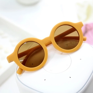 Detail of round matte yellow kids sunglasses with UV400 lens and CE marking
