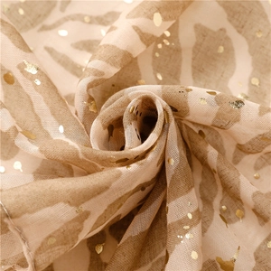 Macro detail of zebra print scarf showing metallic gold dots and soft gauze texture